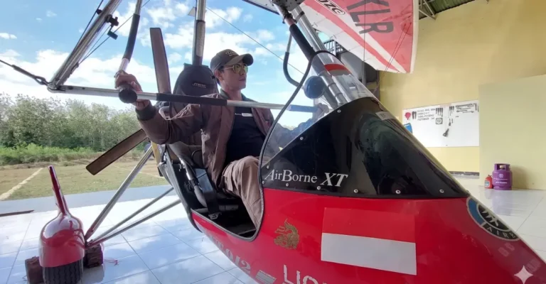 Pesawat microlight patroli udara TN Alas Purwo terparkir di hanggar Resor Kucur, menunjukkan pilot di kokpit dengan latar belakang lapangan terbang.