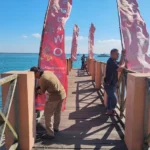 Petugas memasang umbul-umbul di dermaga sebagai bagian dari persiapan petik laut Resor Sembulungan