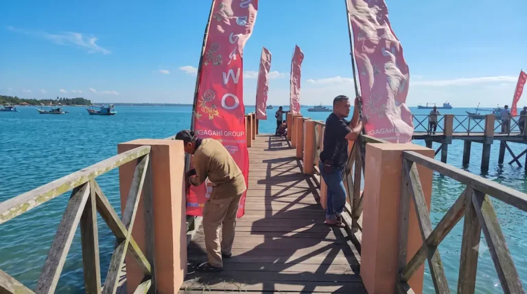 Petugas memasang umbul-umbul di dermaga sebagai bagian dari persiapan petik laut Resor Sembulungan